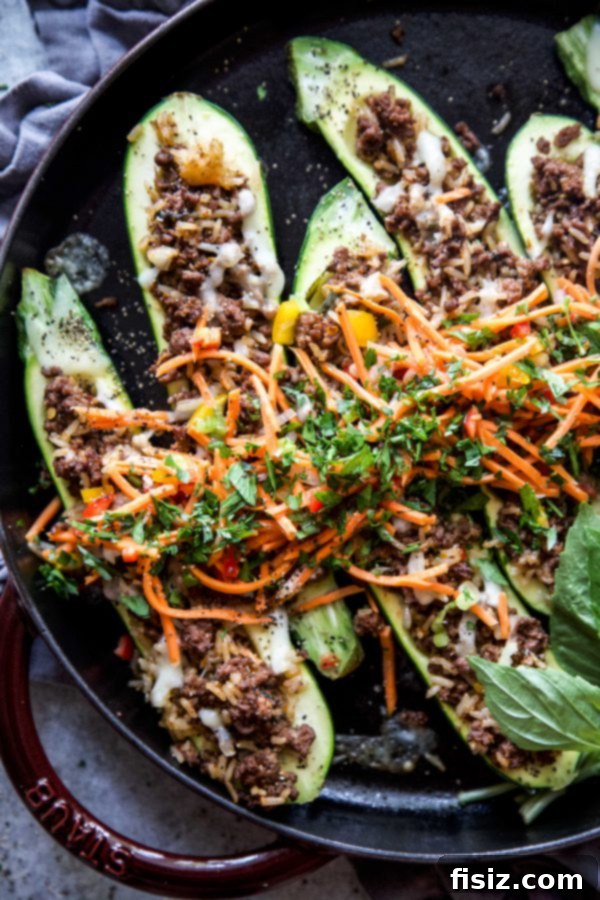 Thai Basil Beef Zucchini Boats 6 A serving of Thai Basil Beef Stuffed Zucchini, freshly baked and garnished with a colorful topping.