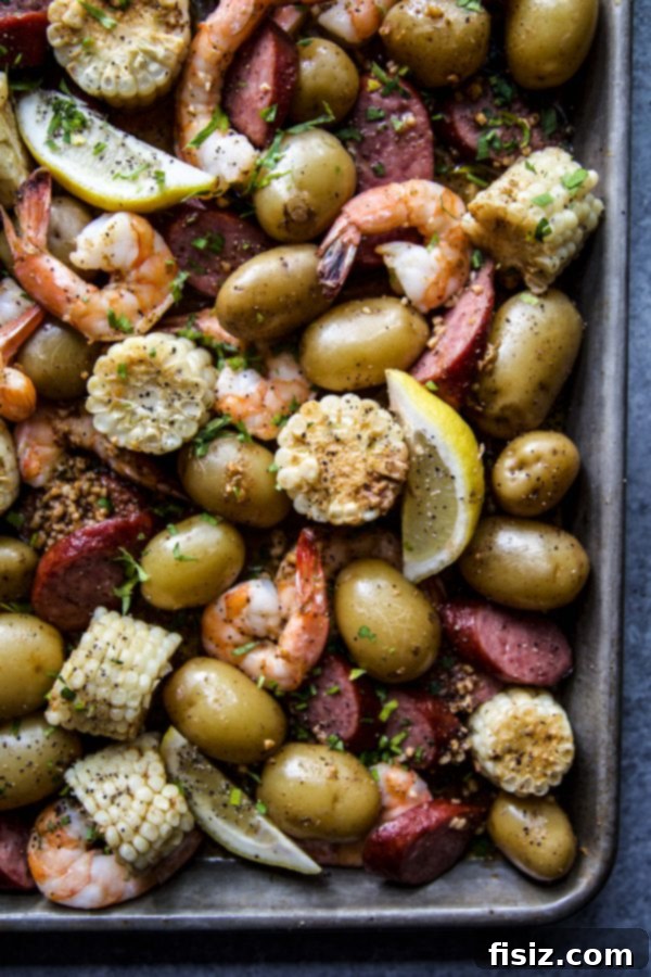 A serving of Sheet Pan Shrimp Boil on a plate, garnished with lemon and fresh parsley