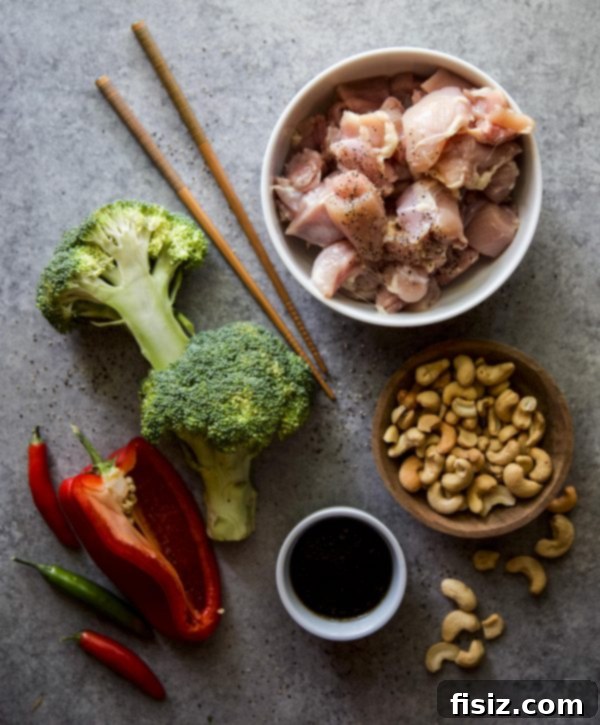 Sticky Honey Garlic Chicken Stir Fry 3 Overhead view of stir fry ingredients including chicken, broccoli, bell pepper, and cashews in a skillet before sauce is added.