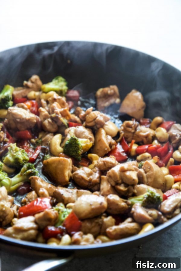 Sticky Honey Garlic Chicken Stir Fry 4 Vibrant Honey Garlic Chicken Stir Fry being tossed in a large skillet, showcasing the glossy sauce and fresh ingredients.