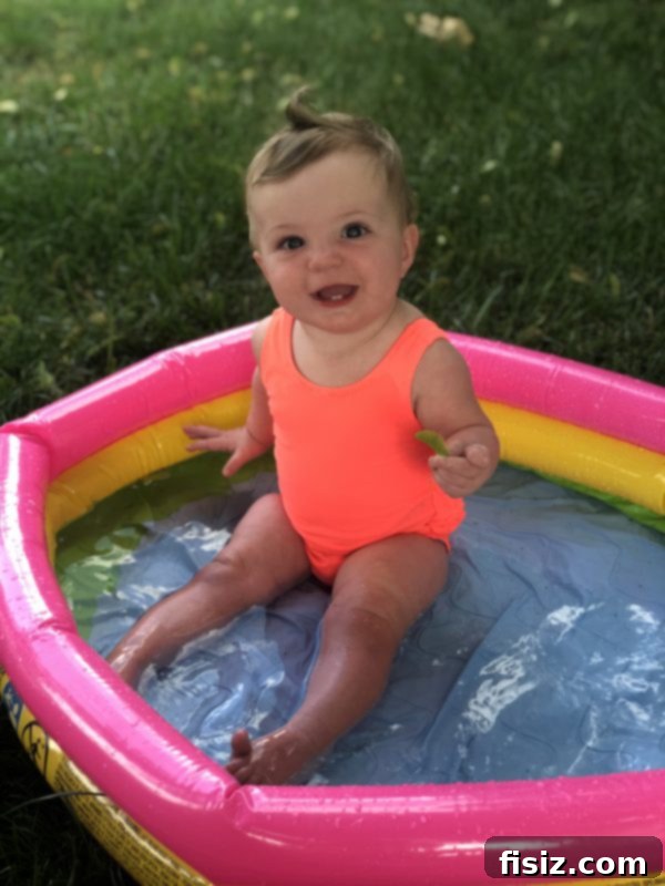 Ten Months of Life with Charlie 12 Charlie enjoying her baby pool in a pink swimsuit