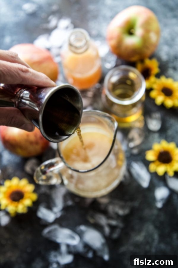 Close-up of a single Apple Bourbon Ginger Spritz cocktail, highlighting the vibrant colors and garnishes