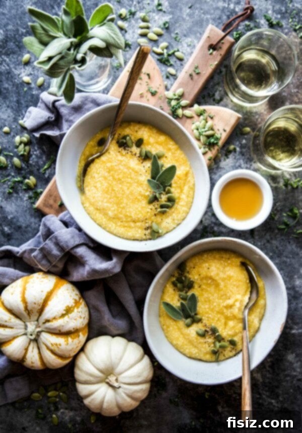 Creamy Maple Roasted Pumpkin Grits 2 A beautifully presented bowl of Maple Roasted Pumpkin Grits, garnished with green pepitas, on a rustic surface.