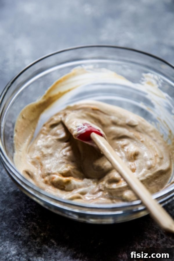 Spiced Pecan Chicken Bites & Chipotle Mustard Dip 6 A small bowl of creamy Chipotle Mustard dipping sauce, garnished with a sprinkle of paprika.