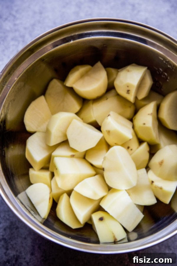 Effortless Mashed Potatoes with a Crispy Chip Crown 4 Ingredients laid out for making mashed potatoes, including Yukon Gold potatoes, butter, and cream
