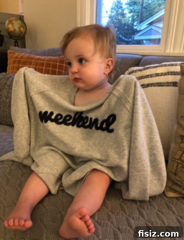 Our First Year with Charlie 17 Charlie lounging on a couch in a cozy sweatshirt, depicting a warm family moment.
