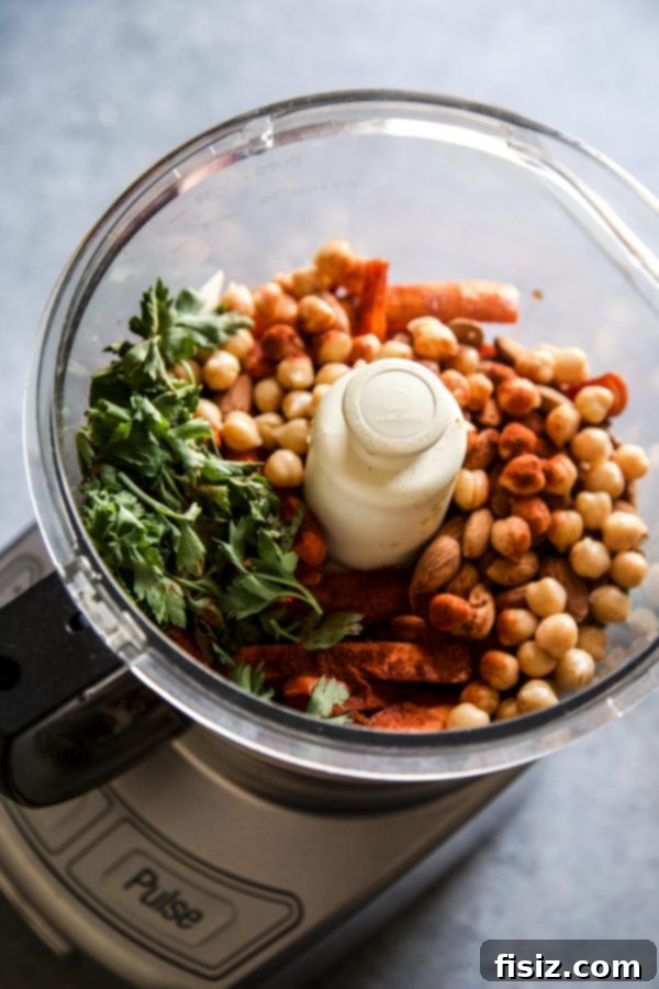 Smoky Roasted Carrot Spread 5 All the essential ingredients for the Smoky Carrot Dip – roasted carrots, garlic, chickpeas, lemon, paprika, parsley, olive oil, and almonds – gathered in a food processor, ready to be blended into a smooth, creamy dip.