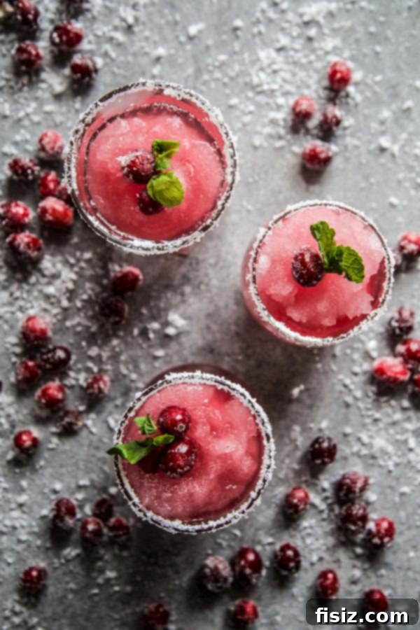 Mistletoe Kiss Margaritas 6 A tray of Mistletoe Margaritas garnished with sugared cranberries and mint, ready to serve.
