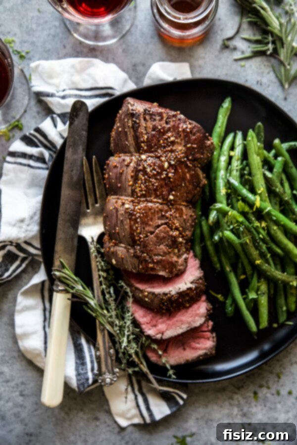 Signature Maple-Mustard Roasted Beef Tenderloin 2 roasted beef tenderloin on a plate with green beans