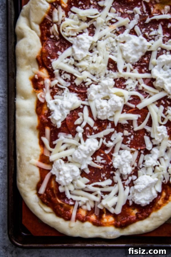 Simple Hot Honey Pepperoni Pizza 5 Dough being par-baked on a baking sheet, ready for toppings