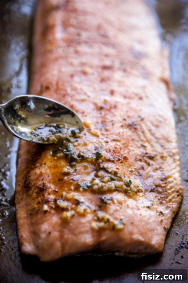 Spicy Cajun Salmon with Rich Garlic Parmesan Sauce 5 Garlic and butter sauce being put on salmon with a spoon.
