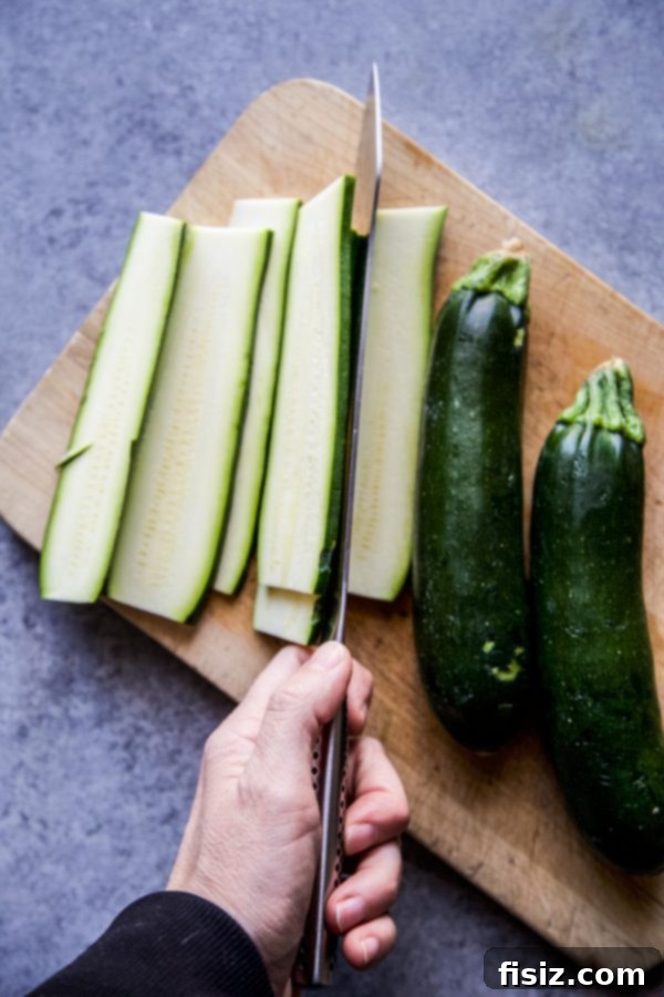 Tex-Mex Zucchini Lasagna 4 Fresh zucchini being sliced thinly on a cutting board, ready for lasagna