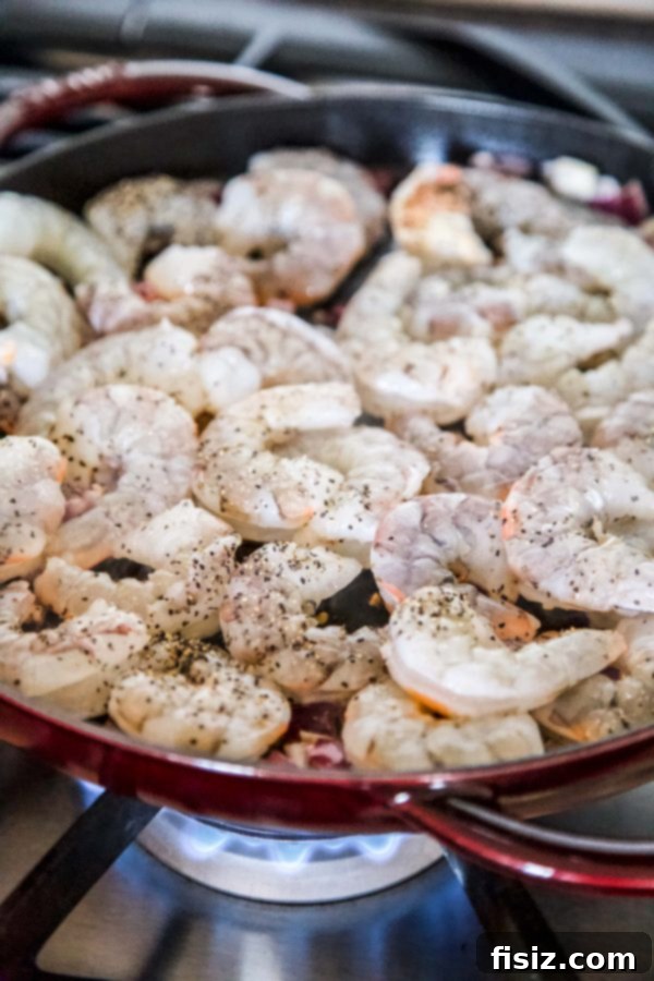 Zesty Salsa Verde Shrimp and Cilantro Rice Skillet 4 Shrimp being cooked in a hot skillet with onions and garlic