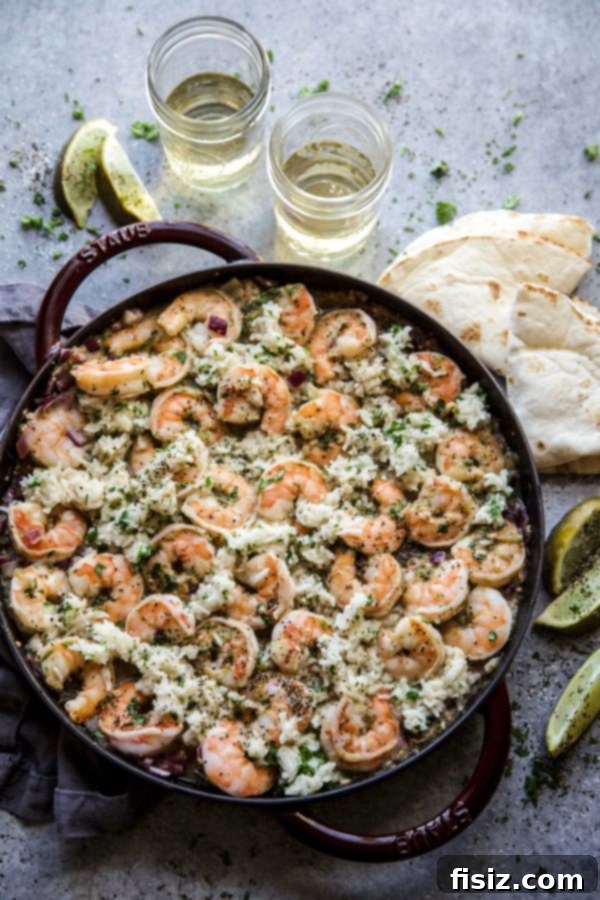 Zesty Salsa Verde Shrimp and Cilantro Rice Skillet 5 Overhead view of the Salsa Verde Shrimp and Cilantro Rice Skillet in a pan, with garnishes