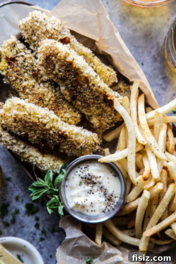 Zaatar Crusted Fish and Chips 3 Close-up of crispy Baked Za'atar Fish Sticks and Chips on a white plate, ready to be served.