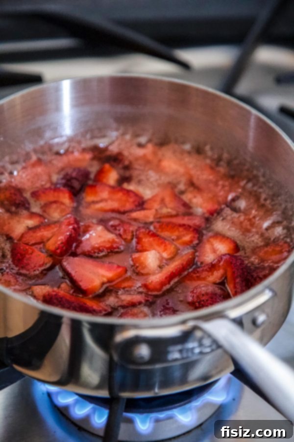 Sweet Strawberry Cardamom Croissants 4 Fresh strawberries simmering in a pan with sugar and lemon juice, beginning to transform into fragrant jam