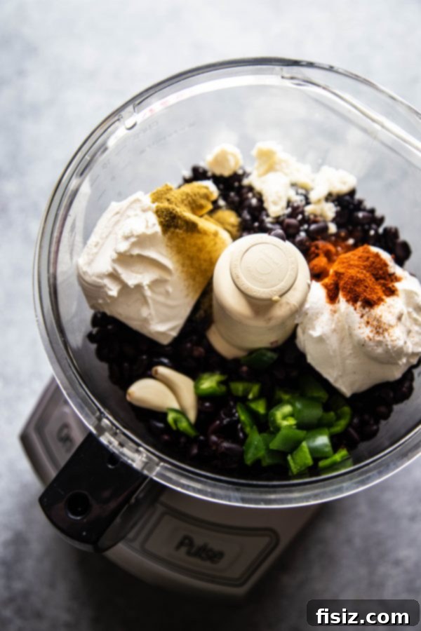 The Perfect Black Bean Dip 3 ingredients used to make the black bean dip in a food processor