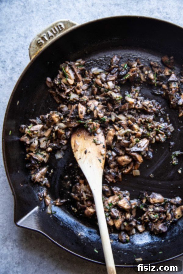 Lamb Wellington 5 Finely chopped mushrooms sizzling in a skillet, creating a rich duxelles for the Wellington