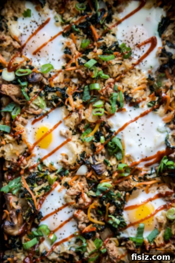 Close-up of a sizzling Bibimbap Casserole with Ground Pork in a cast-iron skillet, ready for baking