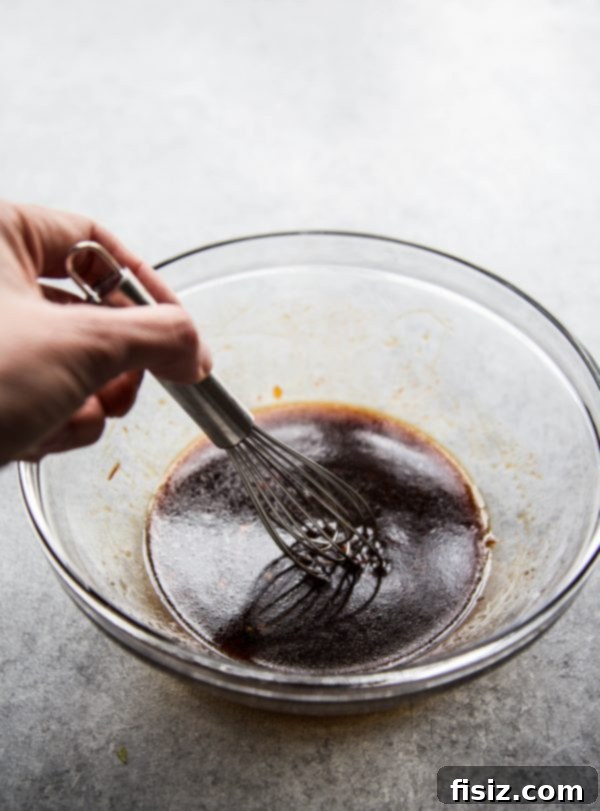 A bowl filled with the rich, red Gochujang sauce, prepared for Bibimbap Casserole