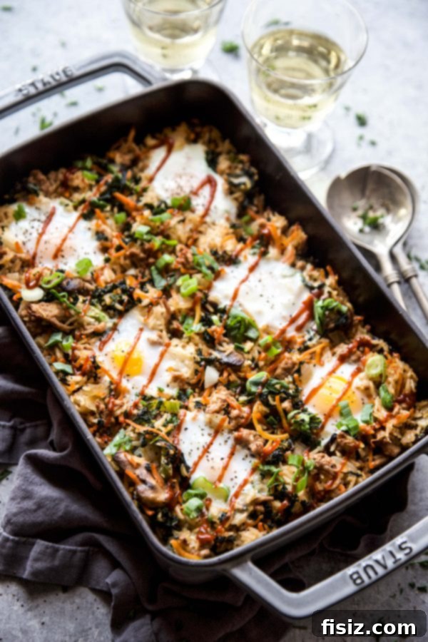 A rustic cast-iron skillet filled with Bibimbap Casserole with Ground Pork, beautifully cooked and ready to serve
