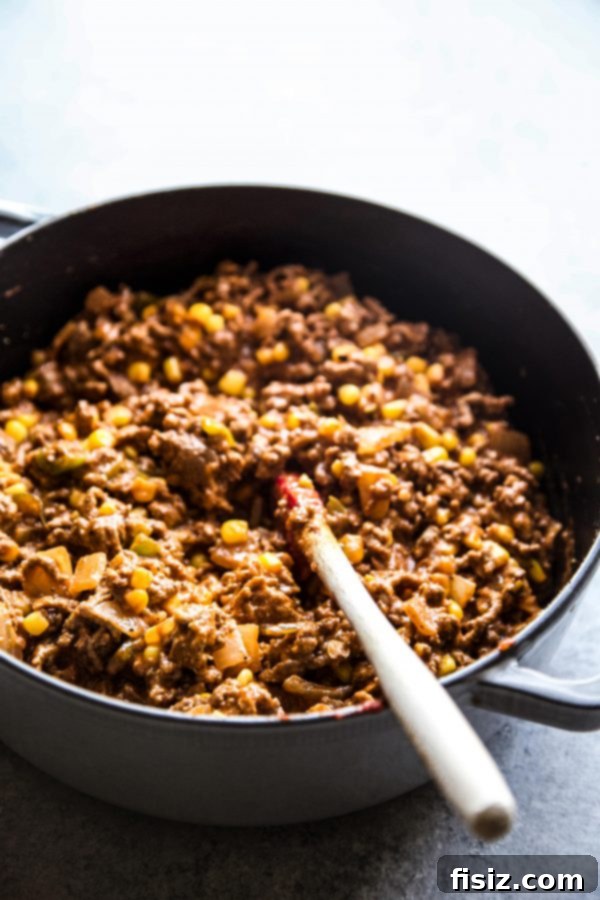 The savory cheeseburger bottom mixture cooking in a skillet