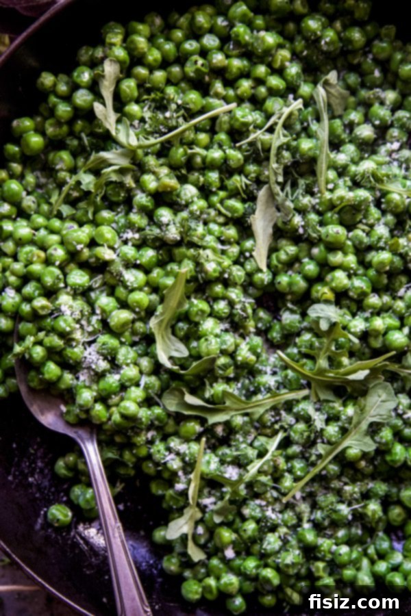 Cacio e Pepe Greens and Peas 3 A close-up of Peas and Greens with Cacio e Pepe Dressing in a bowl, highlighting the creamy texture of the dressing clinging to the vegetables. www.climbinggriermountain.com
