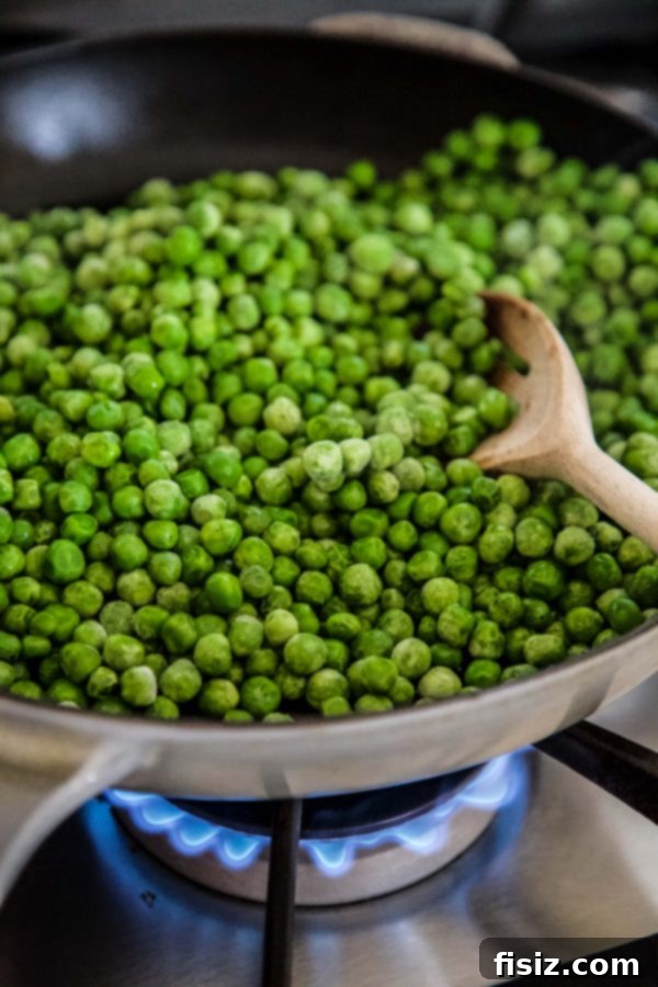 Cacio e Pepe Greens and Peas 5 Fresh peas cooking in a skillet, being gently stirred to warm them through before adding the dressing. www.climbinggriermountain.com