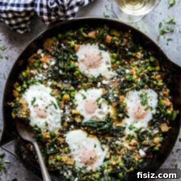 A close-up of Feta, Spinach, & Pea Shakshuka with a focus on poached eggs