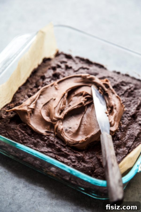 Fudgy Easter Brownies with Decadent Chocolate Cream Cheese Frosting 4 Close-up shot of rich chocolate brownies being generously frosted with creamy chocolate cream cheese frosting.