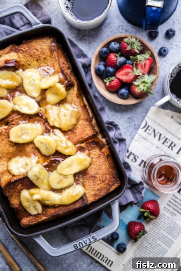 Baked French Toast with Nut Butter and Bananas 3 Overhead view of a cooked Nut Butter-Banana Stuffed French Toast Bake in a glass baking dish, perfect for brunch