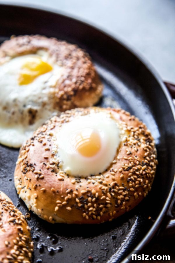 Perfectly baked egg in an everything bagel, garnished with feta and herbs