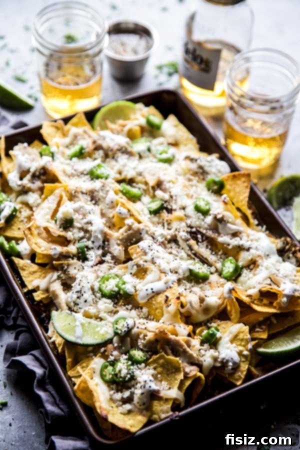 Ultimate Sheet Pan Verde Chicken Nachos 3 Full sheet pan of sizzling Sheet Pan Verde Chicken Nachos straight from the oven, garnished and ready to serve.