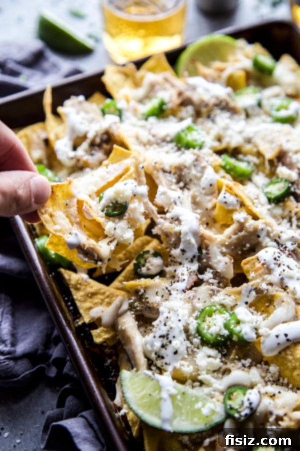 Ultimate Sheet Pan Verde Chicken Nachos 6 A serving of Sheet Pan Verde Chicken Nachos, showcasing the melted cheese and fresh toppings, ready to be enjoyed.
