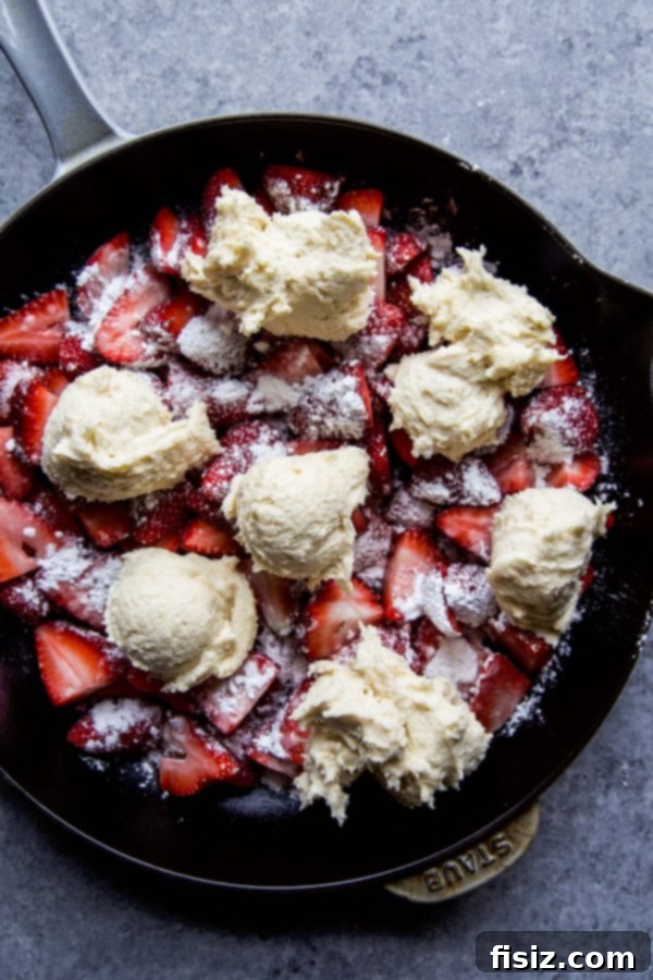 Strawberry Basil Cobbler ready to bake in a cast iron skillet