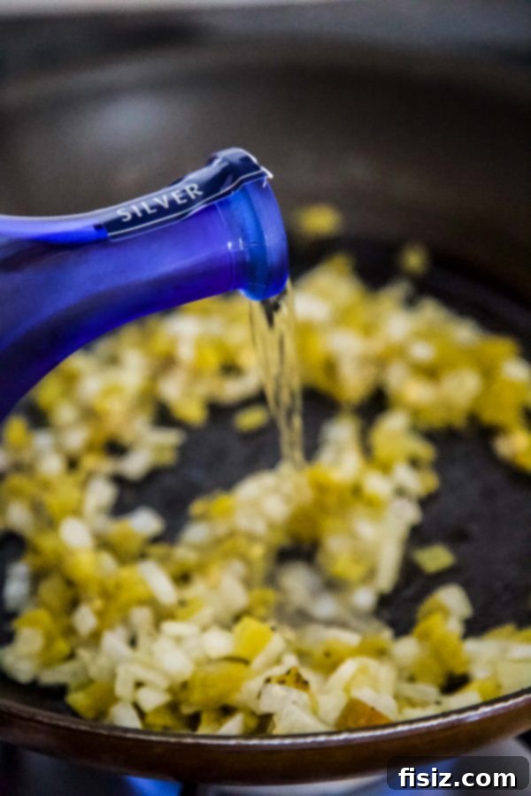 Drunken Chicken Queso Fundido 4 Tequila being poured into a skillet for Queso Fundido