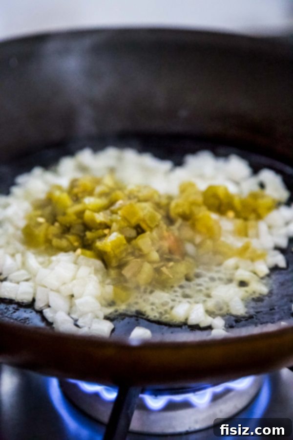 Drunken Chicken Queso Fundido 5 Green chiles and onions sautéing in a skillet