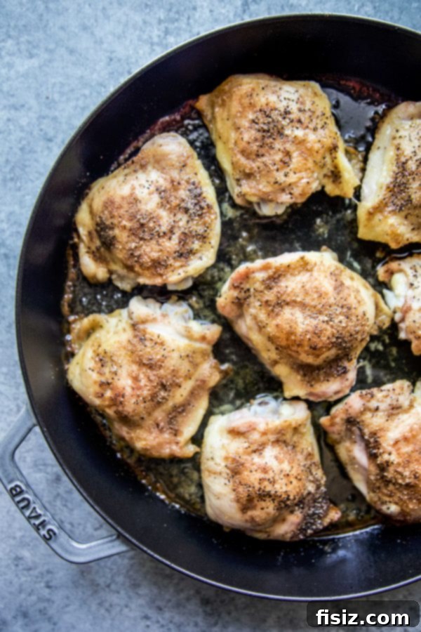 Bright Mediterranean Chicken Thighs with Lemon Cucumber Relish 3 Perfectly roasted chicken thighs in a skillet, ready for Mediterranean relish.
