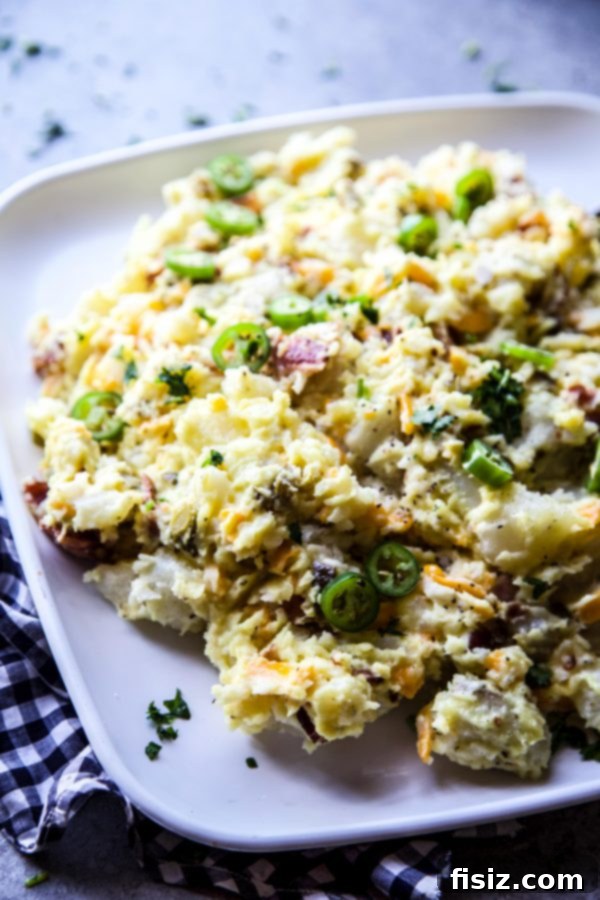 Kickin Popper Potato Salad 5 A large serving bowl filled with creamy Jalapeno Popper Potato Salad, garnished with crispy bacon bits.