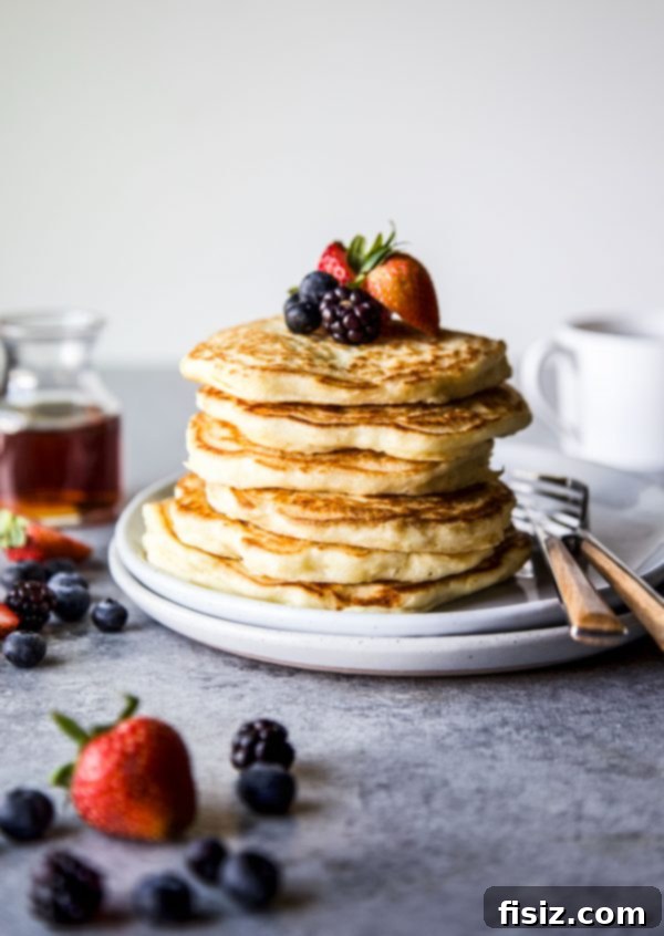 Cloud-Like Soufflé Pancakes with Fresh Berries 3 Close-up view of a serving of fluffy soufflé pancakes with an abundance of mixed berries and syrup
