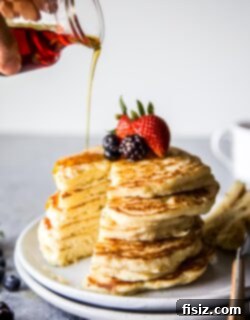 Cloud-Like Soufflé Pancakes with Fresh Berries 8 Souffle Pancakes garnished with berries and syrup in a serving plate