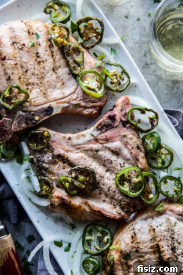 Jalapeno Infused Grilled Pork Chops 3 Close-up of raw pork chops soaking in a vibrant jalapeno marinade, ready for grilling.