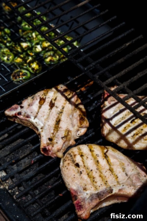 Jalapeno Infused Grilled Pork Chops 5 Grilled jalapenos next to perfectly seared pork chops, highlighting a smoky marinade.