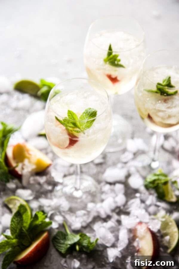 Golden Hour Sangria 2 Vibrant Sunset Sangria in a glass, garnished with nectarine slices and mint, against a summer background