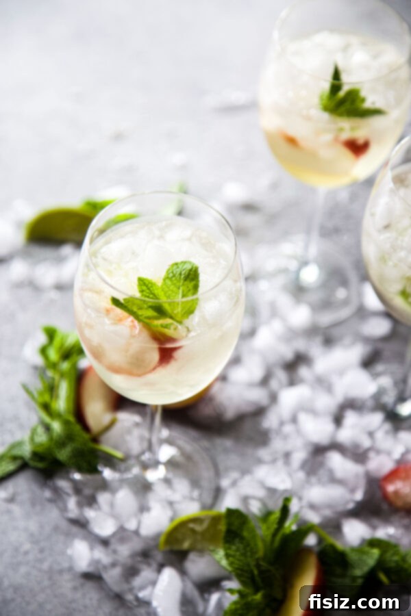Golden Hour Sangria 3 Close-up of a glass of Sunset Sangria with ice, nectarine slices, and mint garnish