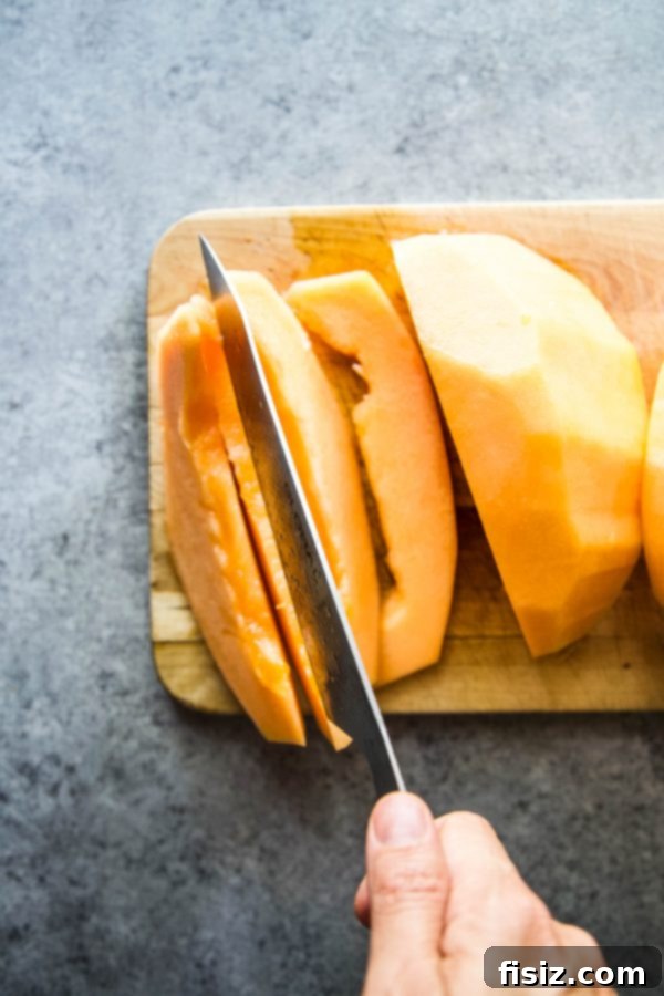Savory Melon Crunch 7 Neatly sliced cantaloupe arranged on a cutting board, ready for serving with the crumble topping.