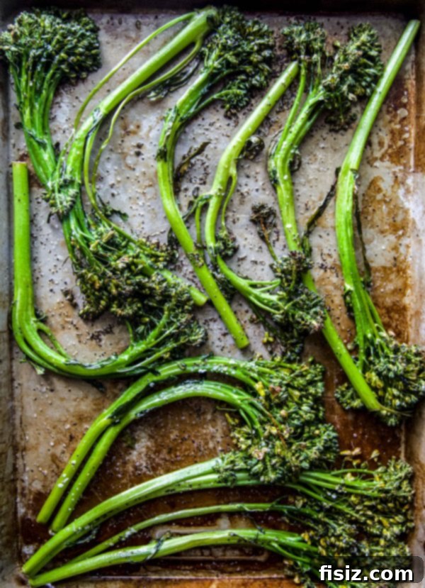 Cheesy Broccolini Sandwiches Made Easy 4 Roasted broccolini spears evenly spread on a baking sheet, ready for the oven.