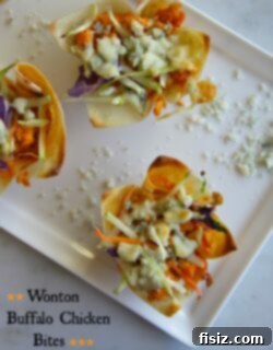 Friday Feast Game Day Buffalo Chicken Wonton Bites 2 A close-up shot of crispy Wonton Buffalo Chicken Bites with blue cheese melting on top, garnished on a plate.
