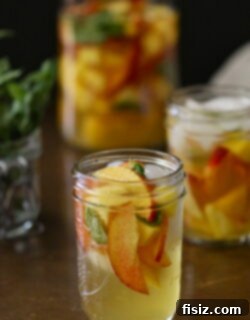 Vibrant Peach Mango Mint Sangria 2 Finished Mango, Mint, and Peach Sangria in a pitcher with glasses