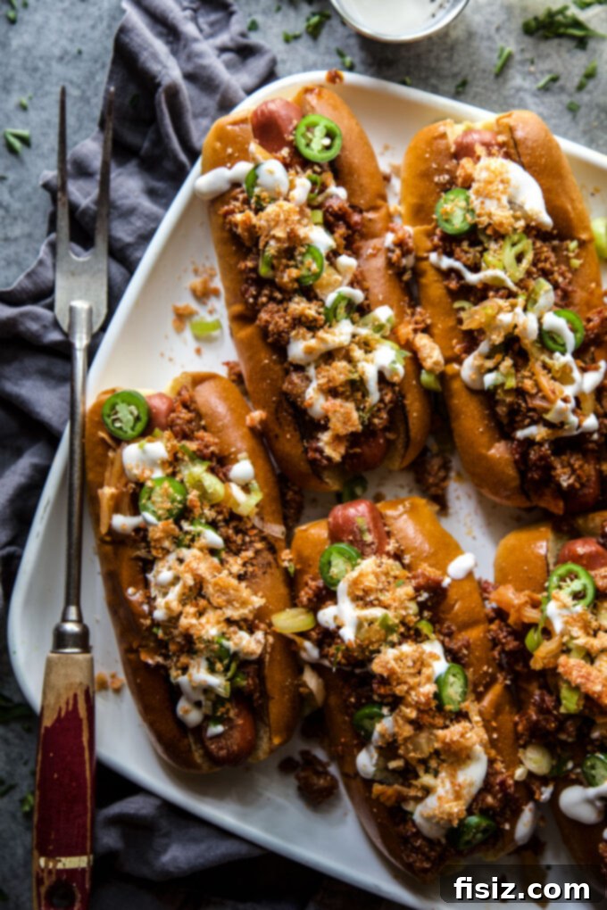 Two Loaded Chorizo & Kimchi Hot Dogs on a wooden board